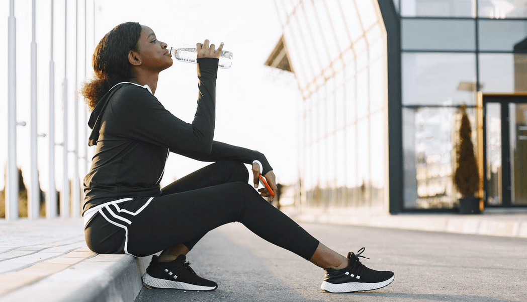 A person holding a water bottle, emphasizing hydration for health