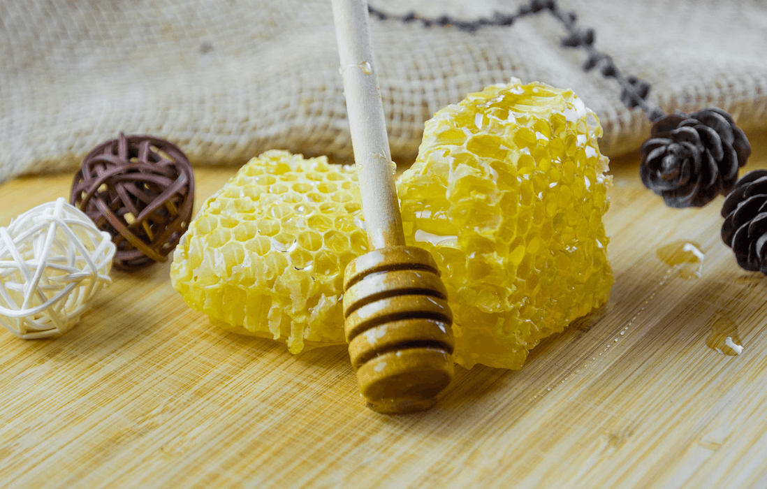 A piece of honeycomb with a honey dripper